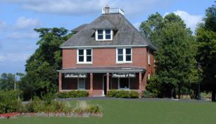 A red farm house with a grey roof.